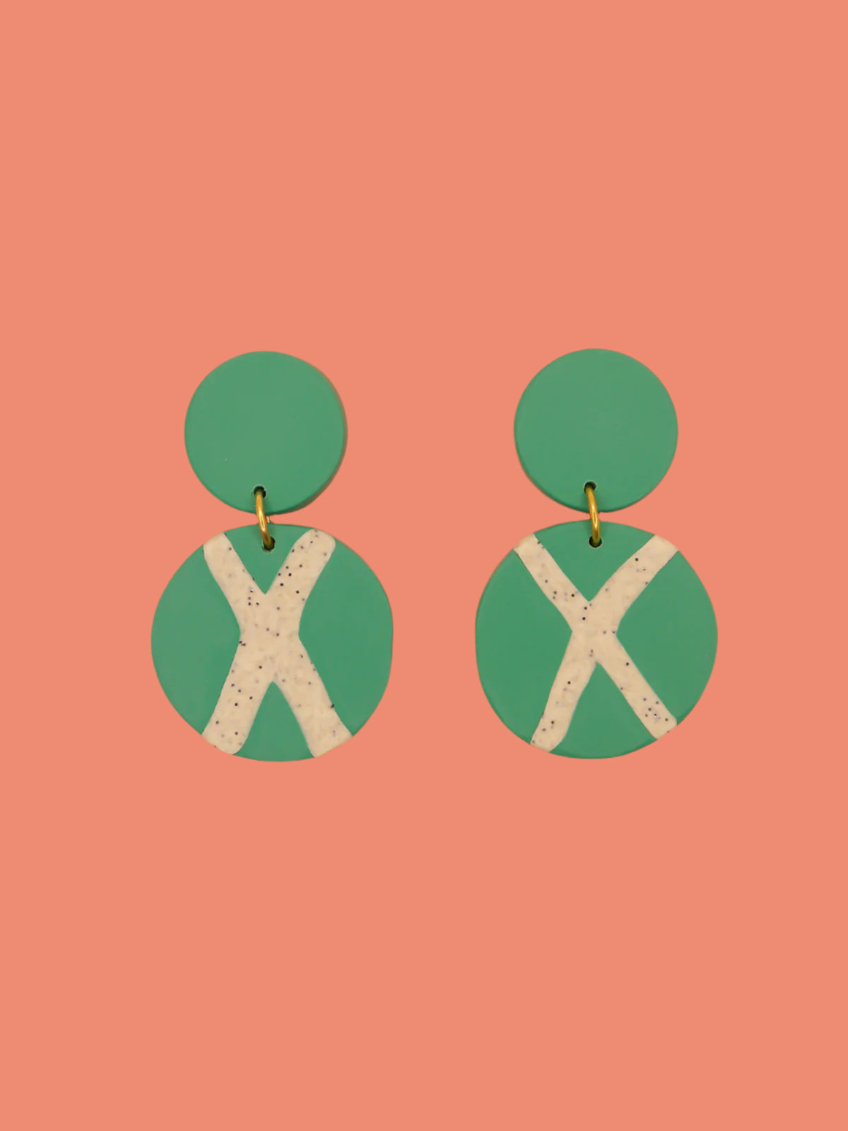 Polymer clay dangle statement earrings with a green stud connected to a green circle with a granite cross in the centre