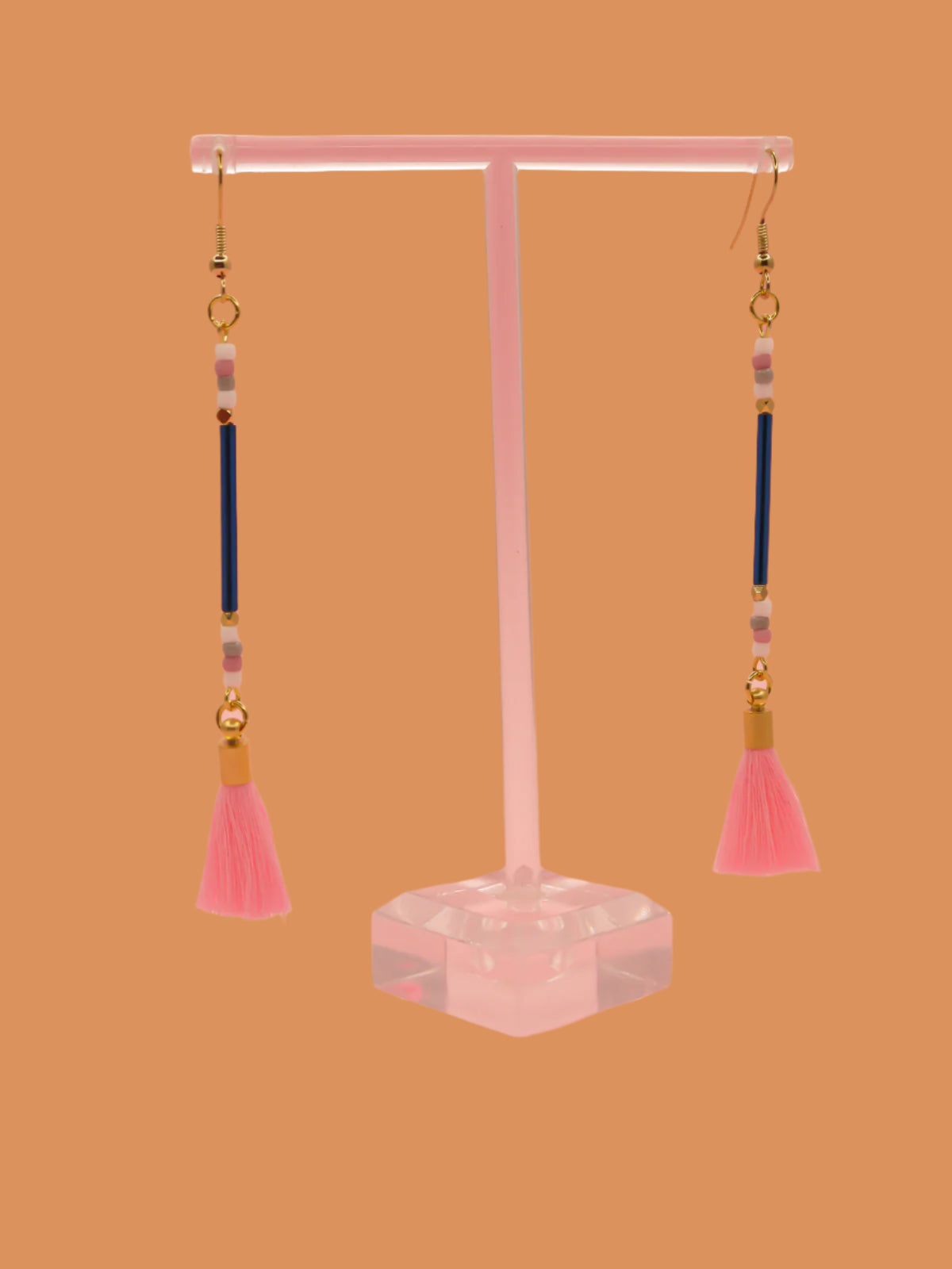 Long beaded tassel earrings with blue glass tube beads and white, pink & grey seed beads with a light pink cotton tassel and hung from gold plated nickel free ear wires