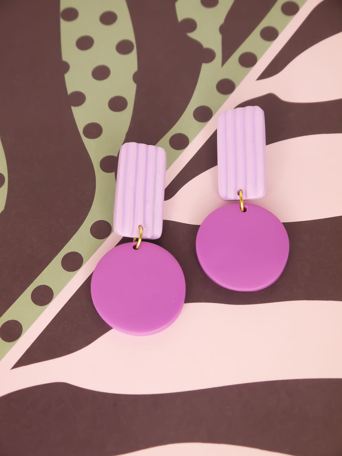 Purple striped geometric earrings on a patterned background