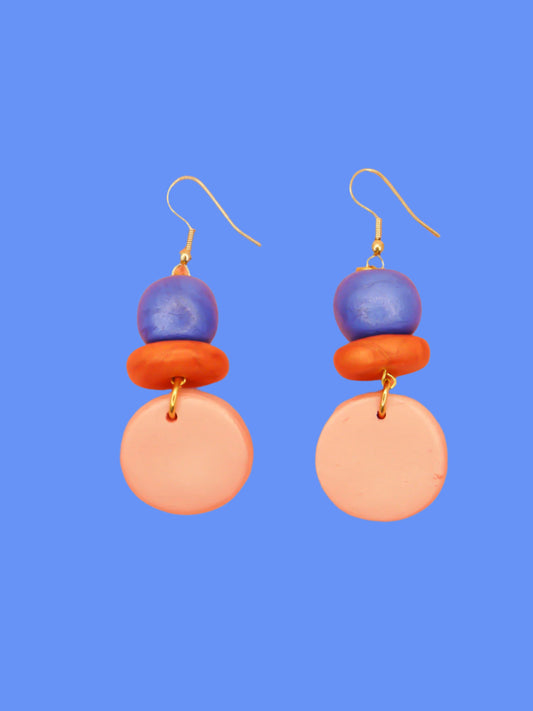 Lightweight metallic beaded dangle earrings with a rose gold circle, topped with hand rolled metallic beads in rust and blue, hung from gold plated ear wires