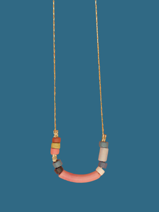 Pink curved bar ceramic bead necklace with colourful ceramic tube and brass beads strung on a gold plated thin chain with clasp