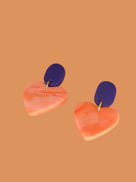 Pink marble heart earrings with a cobalt blue rectangular stud with stainless steel posts made out of polymer clay