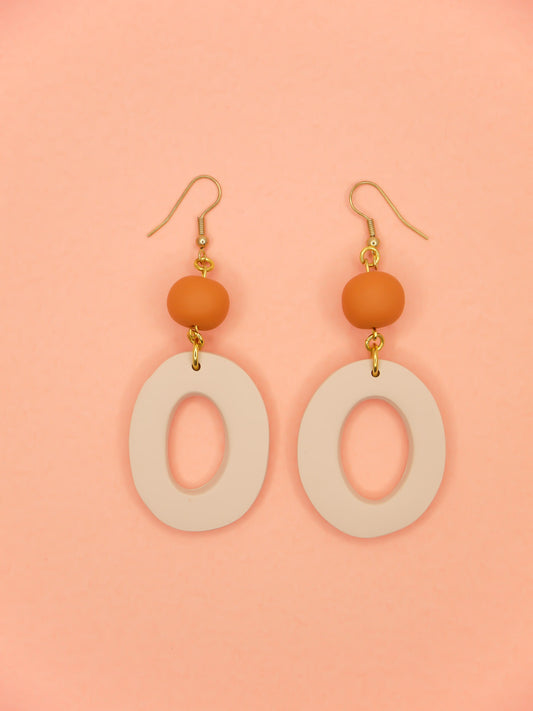 Modern hoop dangle statement earrings with a beige hoop & terracotta bead, hung from brass hooks. Handmade from polymer clay.