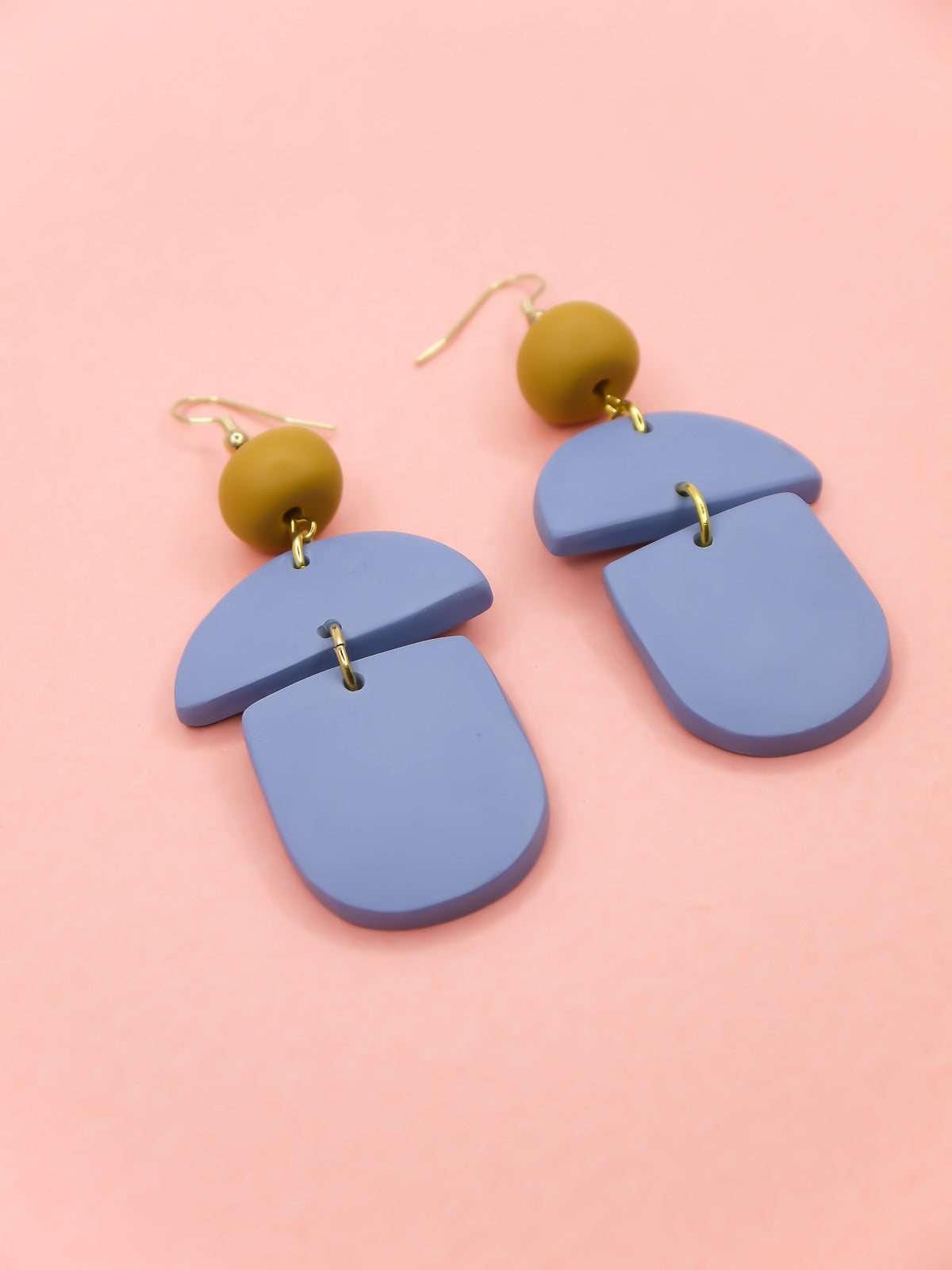 Geometric lightweight dangle statement earrings in bluestone arch and semi circles with a hand rolled mustard bead hung from gold plated nickel free ear wires