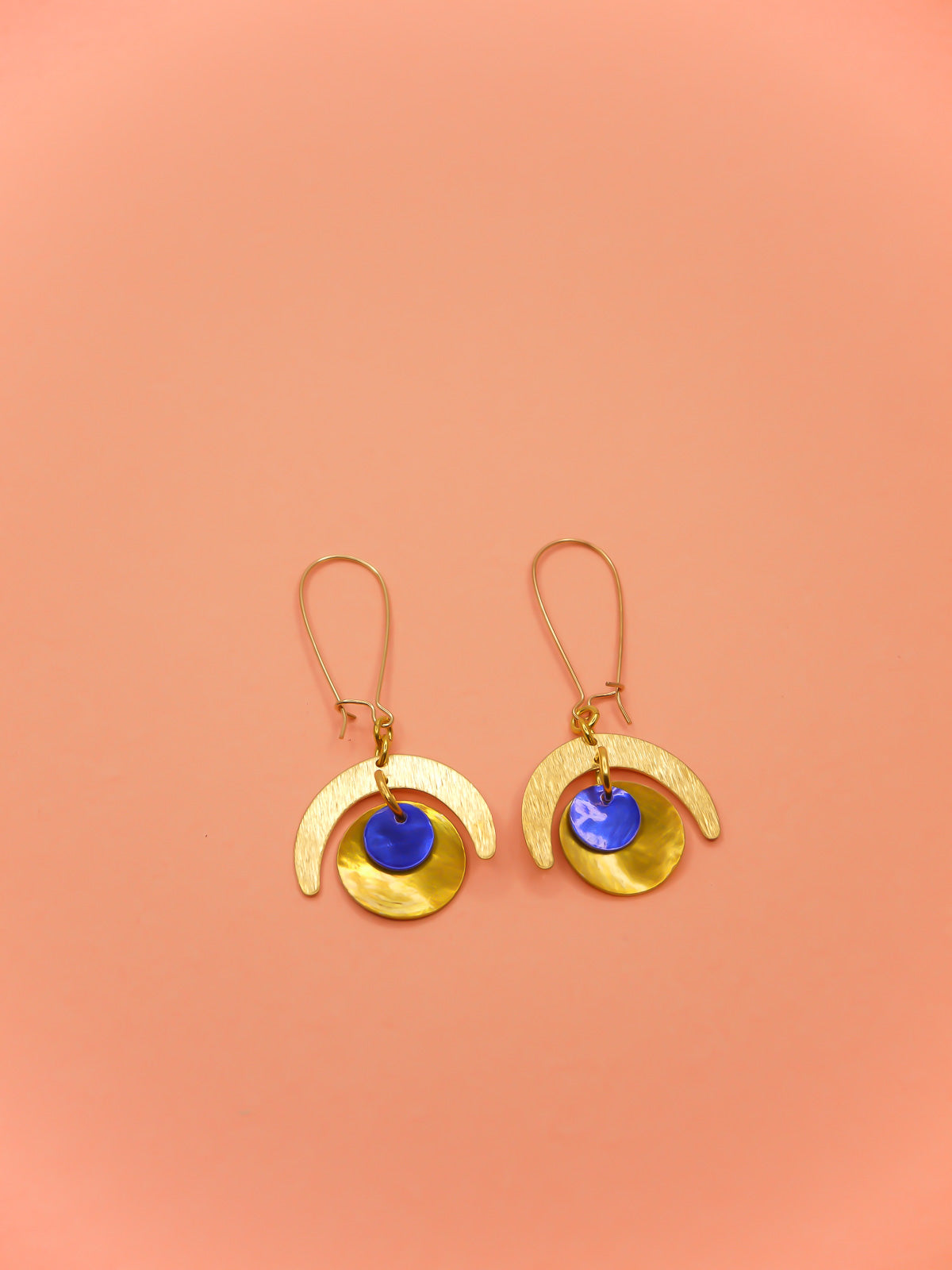 Lightweight geometric dangle earrings with a textured brass semi circle charm & a yellow shell disk with a blue shell disk overlapped, hung from gold plated kidney ear wires