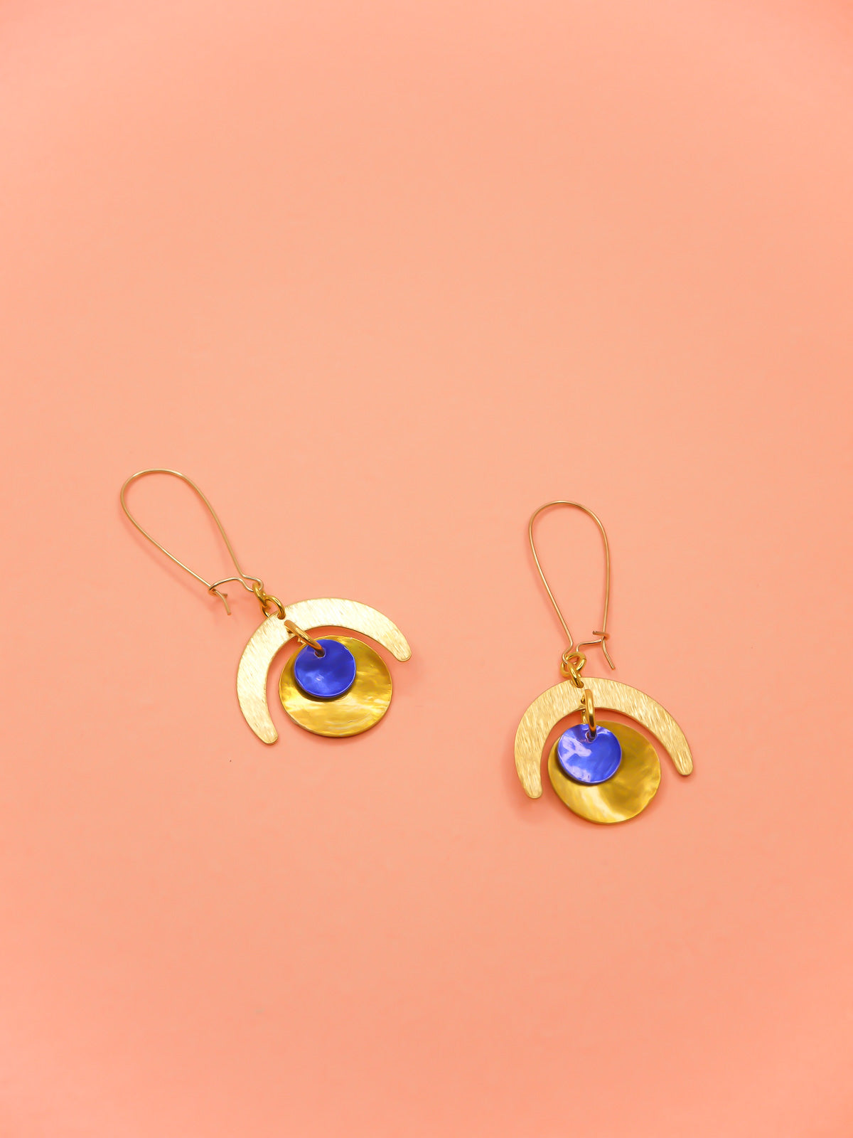 Lightweight geometric dangle earrings with a textured brass semi circle charm & a yellow shell disk with a blue shell disk overlapped, hung from gold plated kidney ear wires