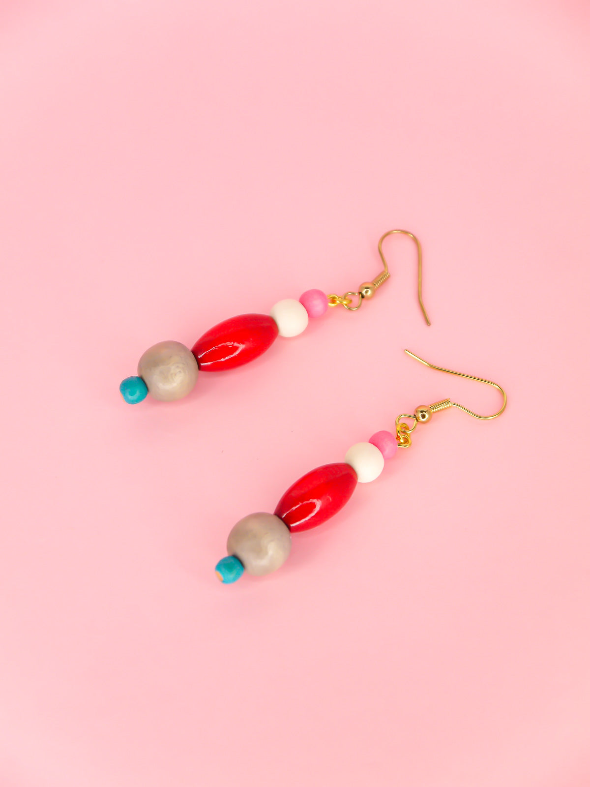 Colourful lightweight wooden bead dangle earrings in various shaped beads in pink, white, red, grey & blue, hung from gold plated ear wires