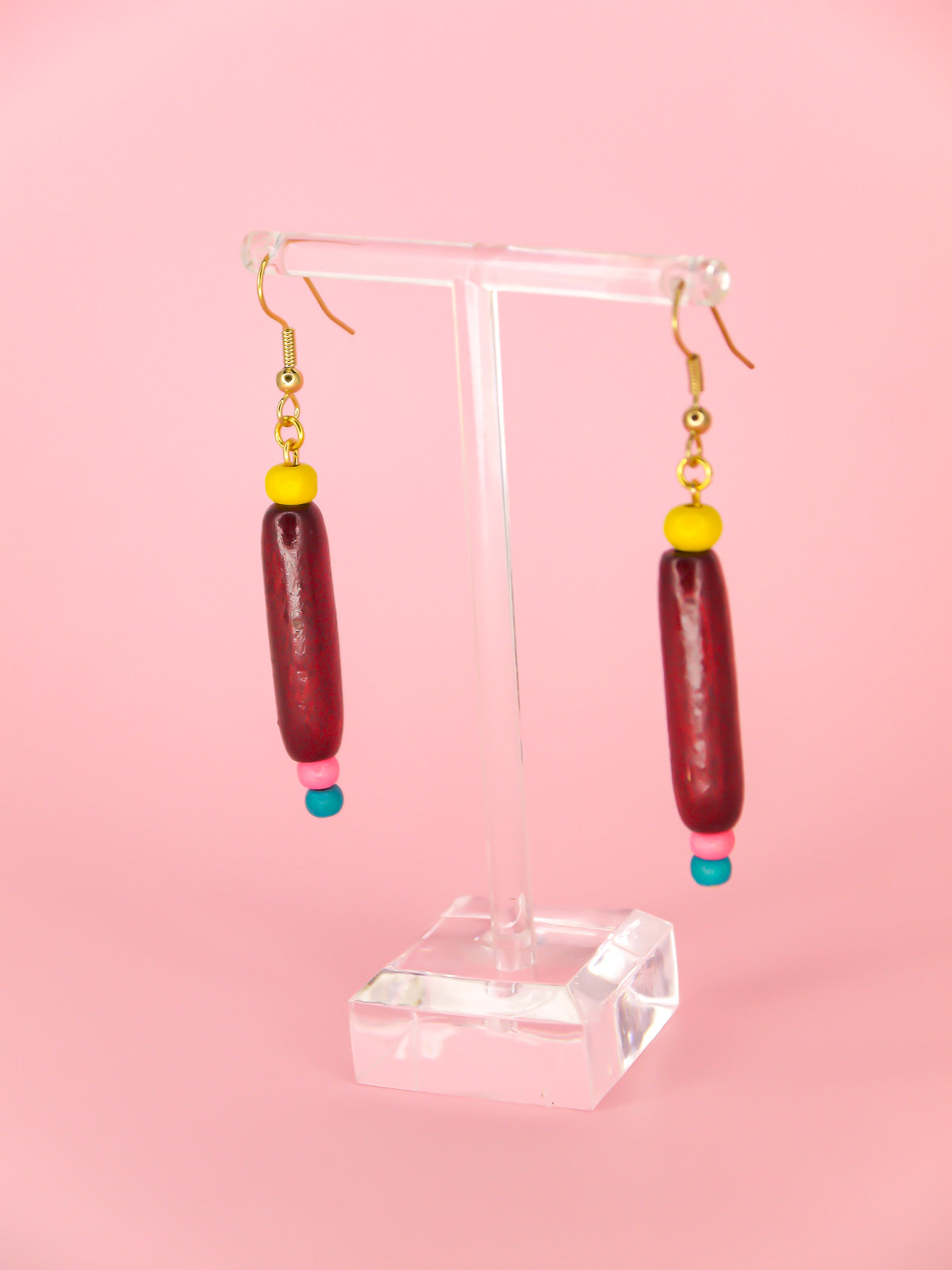 Colourful lightweight wooden bead dangle earrings of various shaped beads in yellow, mahogany, pink & blue, hung from gold plated ear wires