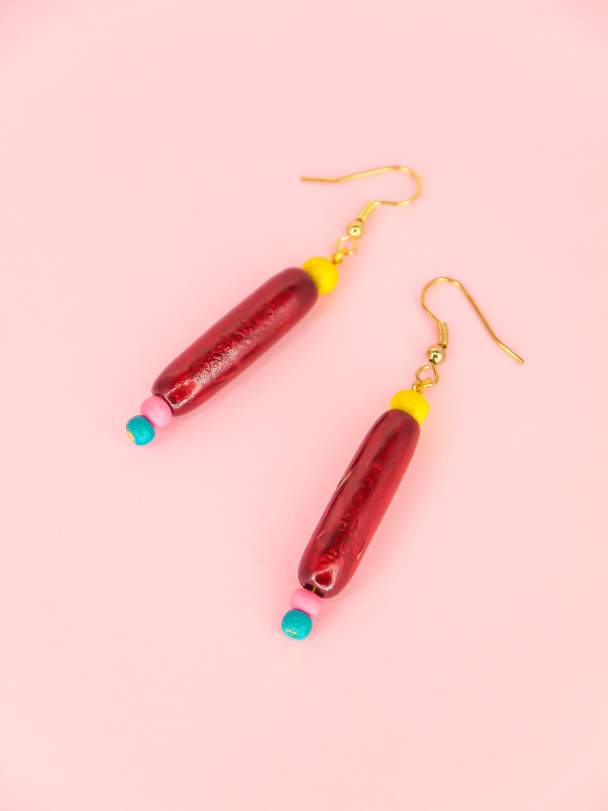 Colourful lightweight wooden bead dangle earrings of various shaped beads in yellow, mahogany, pink & blue, hung from gold plated ear wires