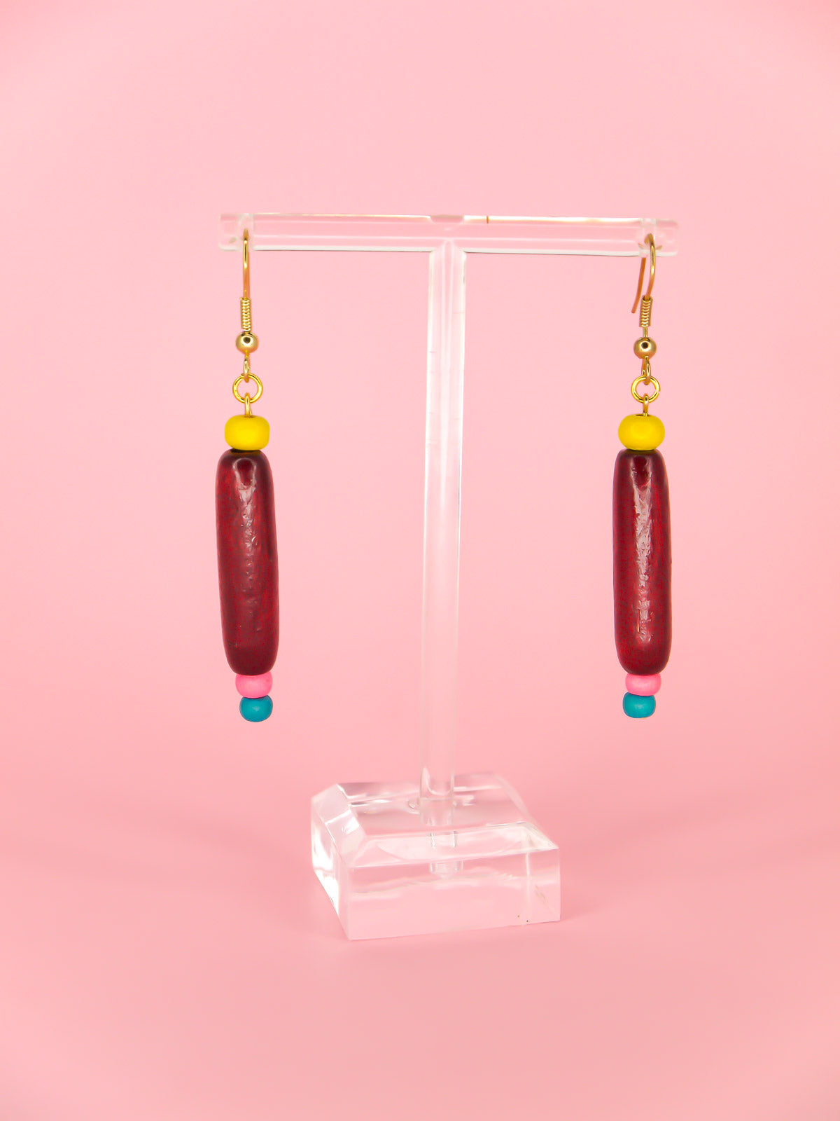 Colourful lightweight wooden bead dangle earrings of various shaped beads in yellow, mahogany, pink & blue, hung from gold plated ear wires