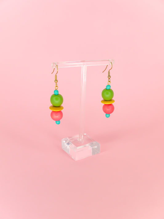 Colourful lightweight dangle earrings in wooden beads of various shapes in blue, green, yellow & pink. Hung from gold plated ear wires.