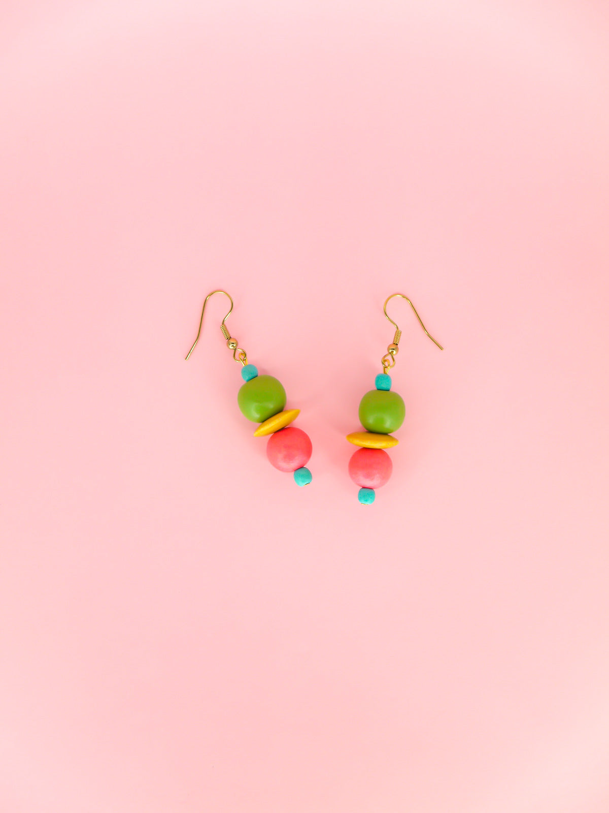 Colourful lightweight dangle earrings in wooden beads of various shapes in blue, green, yellow & pink. Hung from gold plated ear wires.