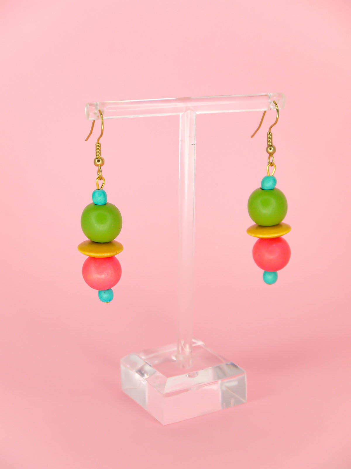 Colourful lightweight dangle earrings in wooden beads of various shapes in blue, green, yellow & pink. Hung from gold plated ear wires.