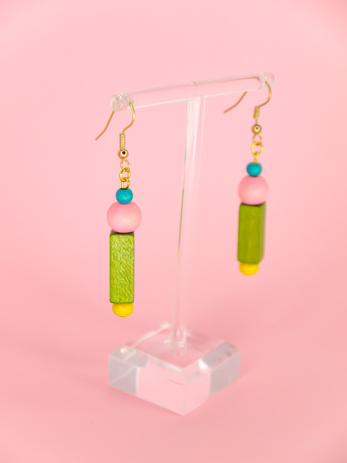 Colourful lightweight dangle earrings in various shaped wooden beads in blue, pink, green & yellow, hung from gold plated ear wires