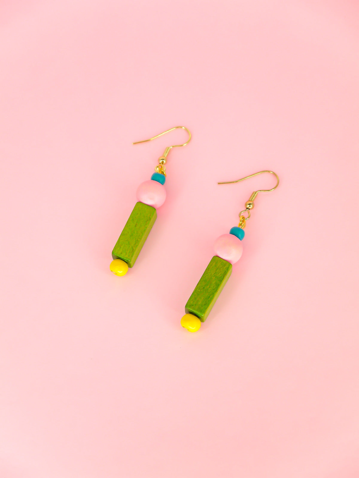 Colourful lightweight dangle earrings in various shaped wooden beads in blue, pink, green & yellow, hung from gold plated ear wires