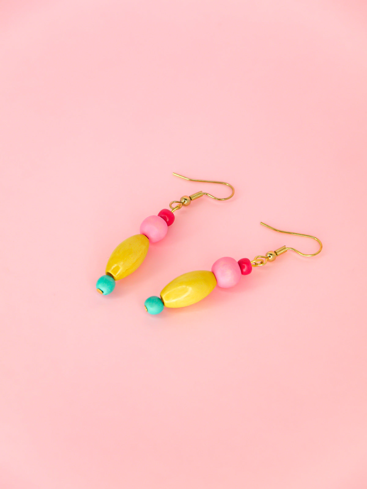 Colourful lightweight wooden bead earrings in various shapes in pink, yellow & blue beads, hung from gold plated ear wires