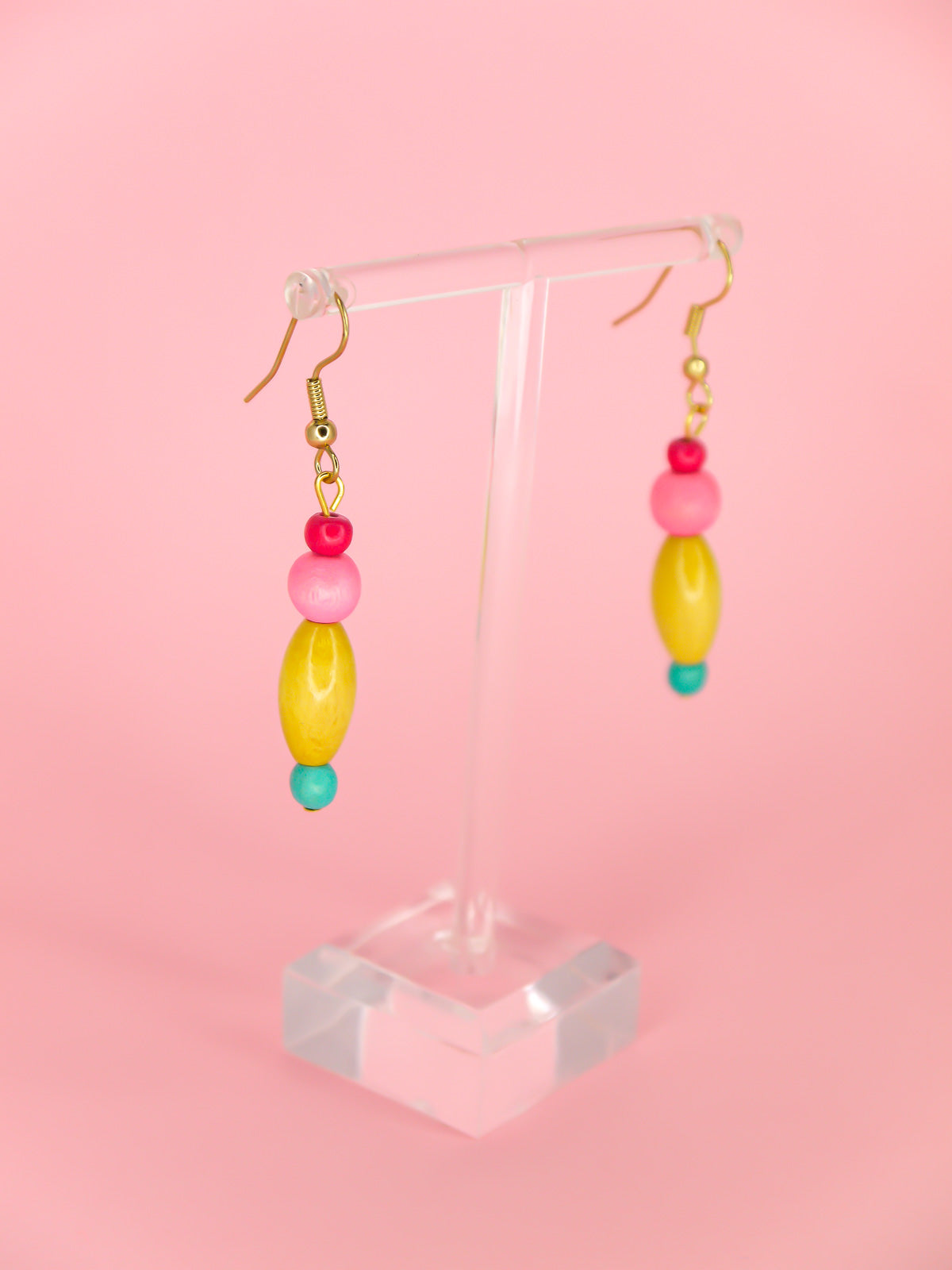 Colourful lightweight wooden bead earrings in various shapes in pink, yellow & blue beads, hung from gold plated ear wires