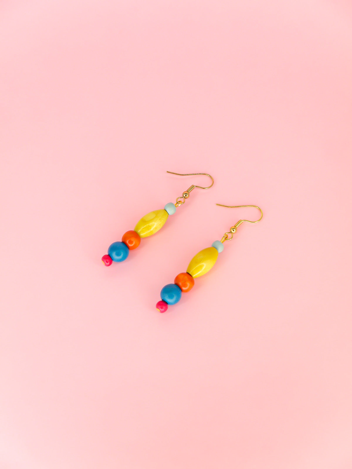 Colourful lightweight wooden bead dangle earrings in various shaped beads in blue, yellow, orange & pink, hung from gold plated ear wires