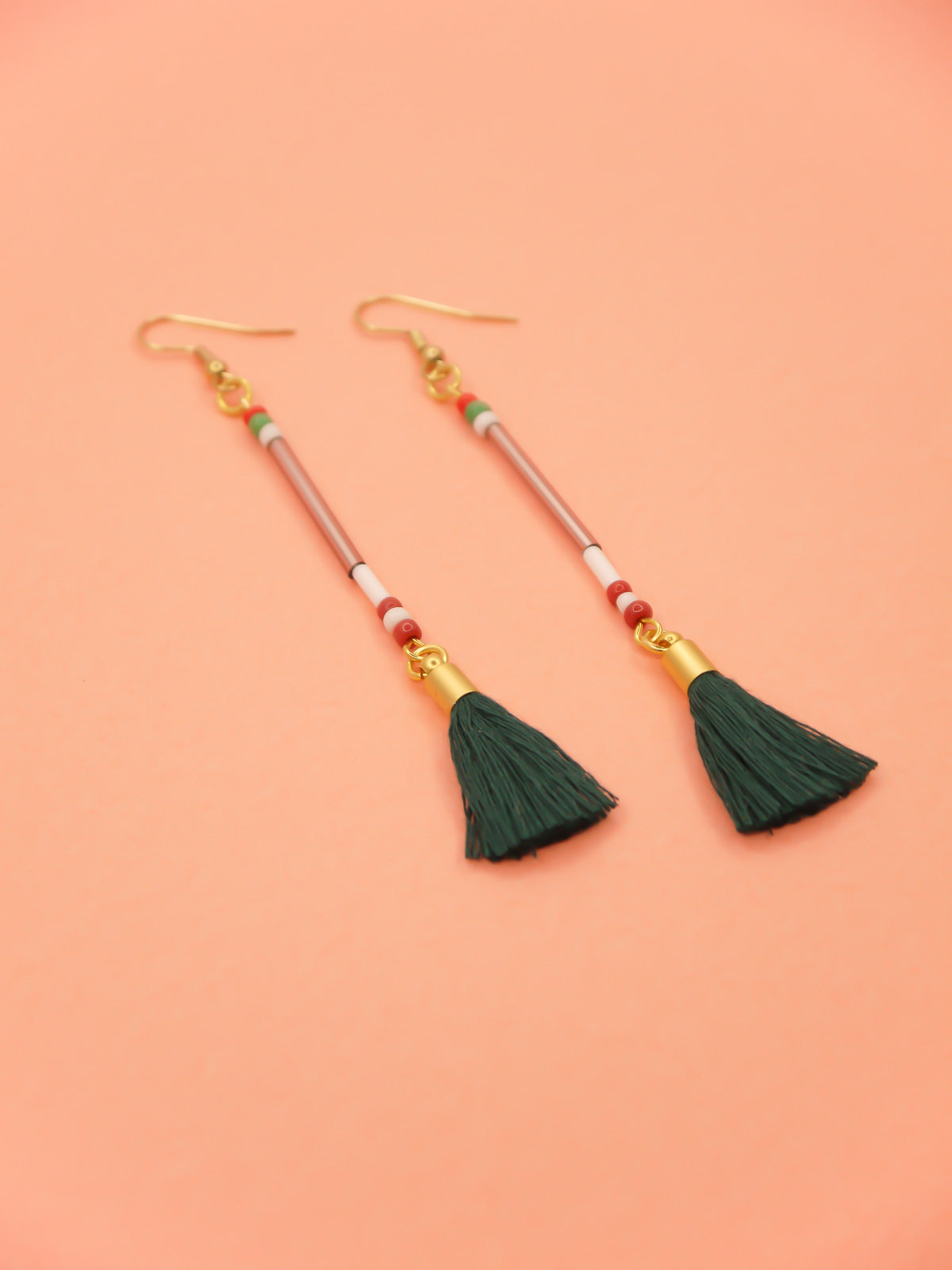 Lightweight long delicate bead stick dangle earrings with lilac glass tube beads & contrasting seed beads in green, white & red, paired with a dark green cotton tassel. Hung from gold plated nickel free ear wires.