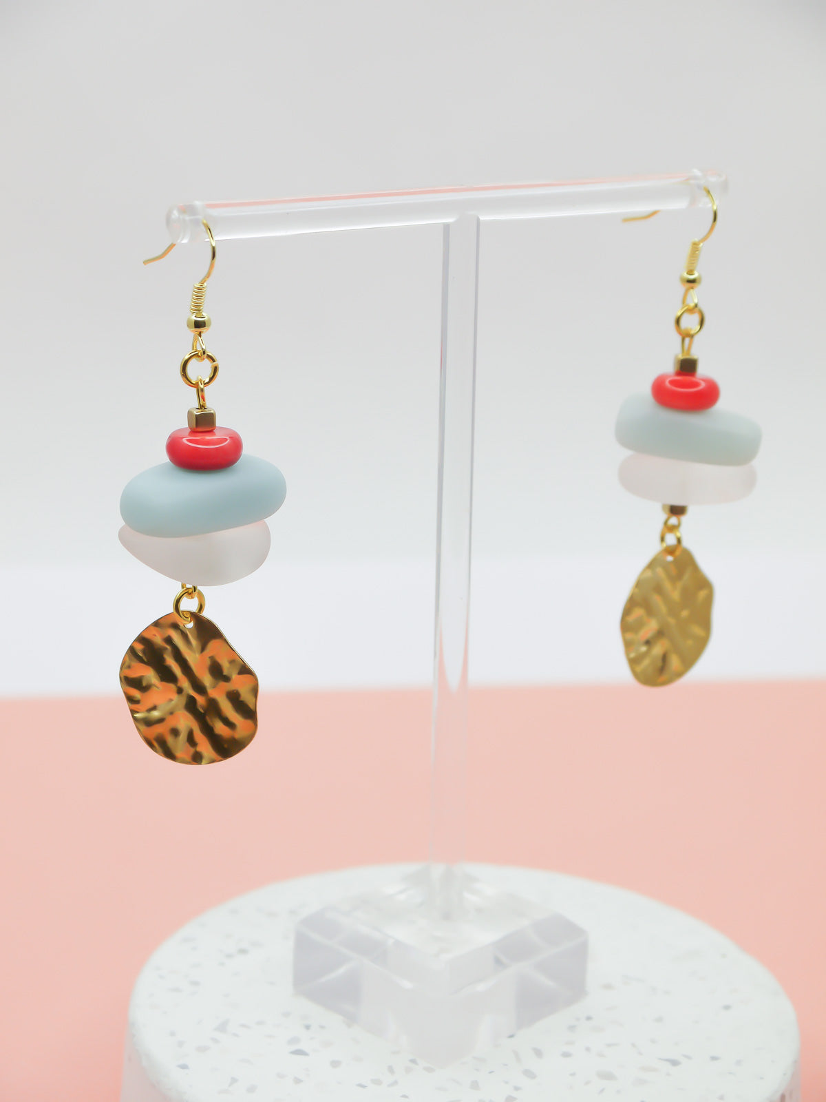 Gemstone crystal earrings with a stack of coral, amazonite and crystal quartz beads with a textured brass medallion charm, hung from gold plated ear wires