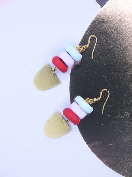 Colourful beaded earrings on a gold foil background