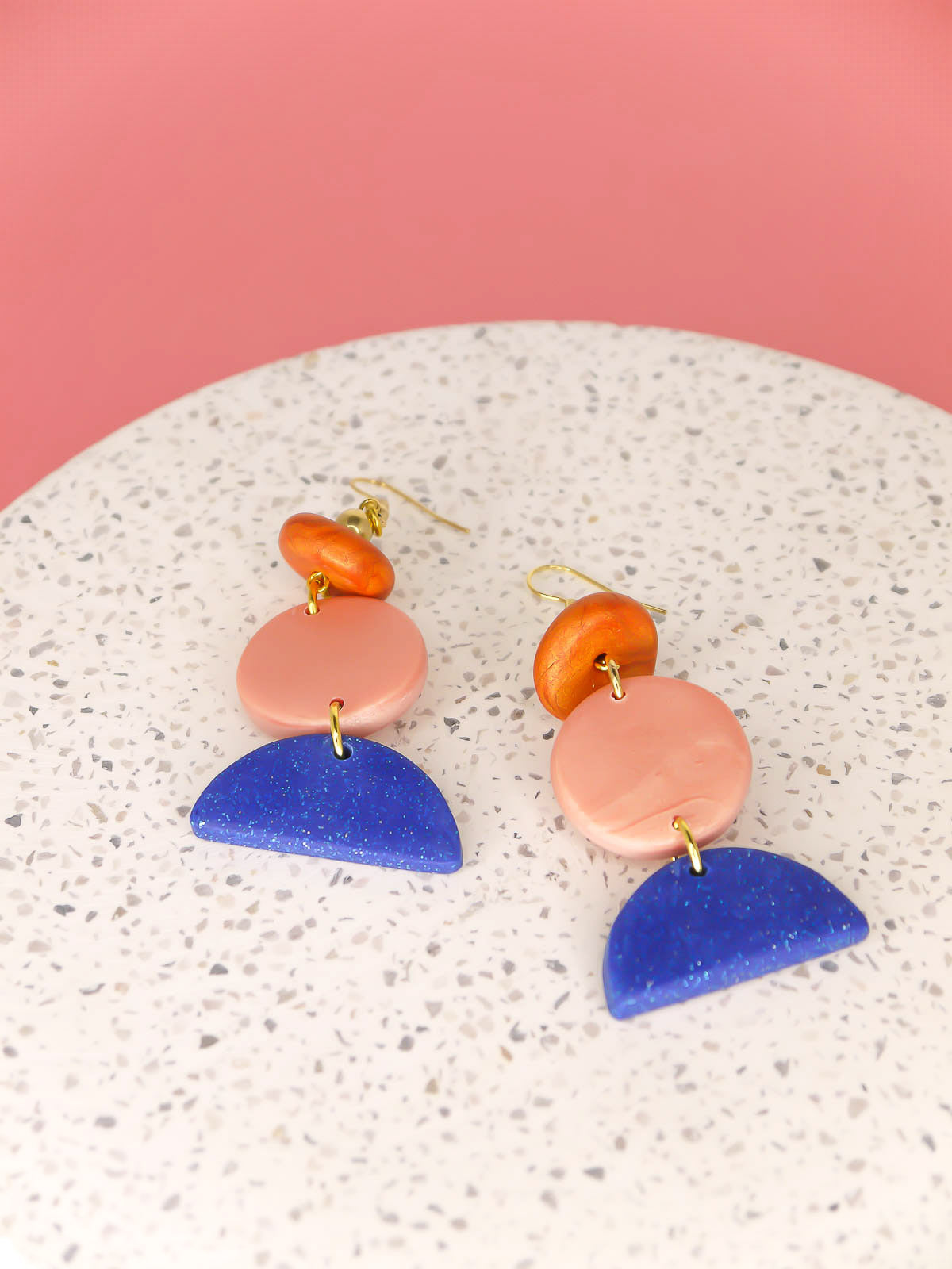 Geometric 3 tier dangle statement earrings with a blue glitter semi circle, rose gold circle & a rust bead, topped with a brass ball bead and gold plated ear wires