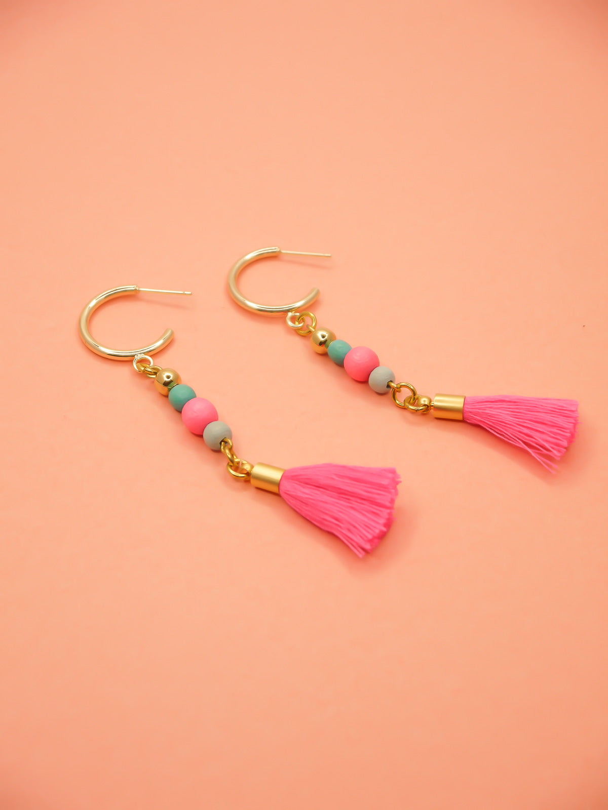 Gold hoop beaded tassel earrings with wooden beads in turquoise, pink & blue with a hot pink tassel and gold hoops