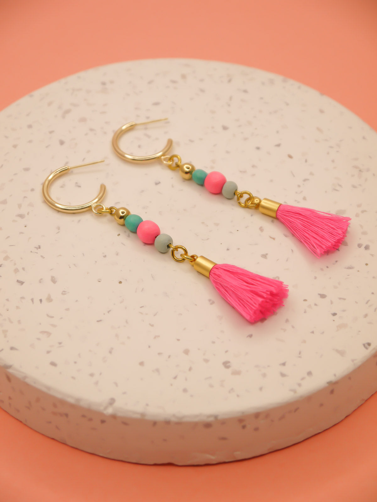 Gold hoop beaded tassel earrings with wooden beads in turquoise, pink & blue with a hot pink tassel and gold hoops