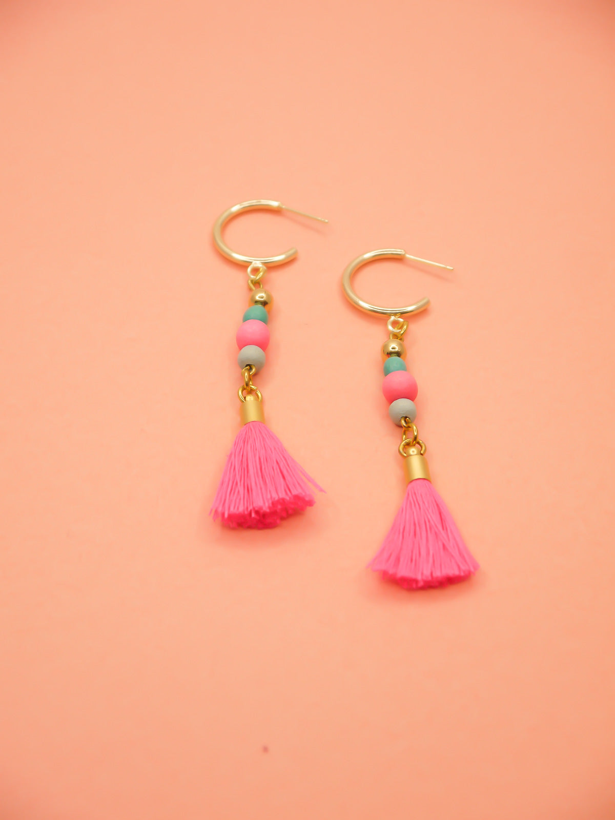 Gold hoop beaded tassel earrings with wooden beads in turquoise, pink & blue with a hot pink tassel and gold hoops