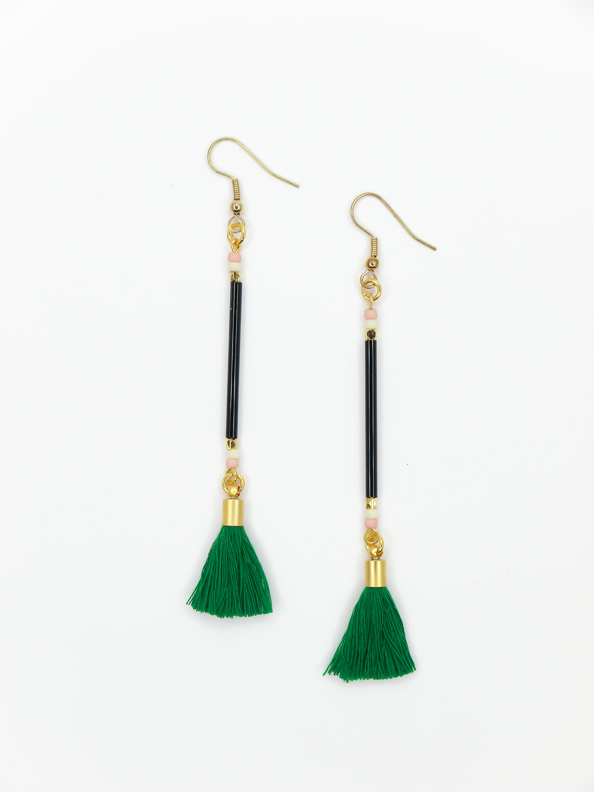 Long delicate bead stick dangle earrings with black glass tube beads & contrasting seed beads in pink & white. Paired with a green cotton tassel & hung from gold plated nickel free ear wires