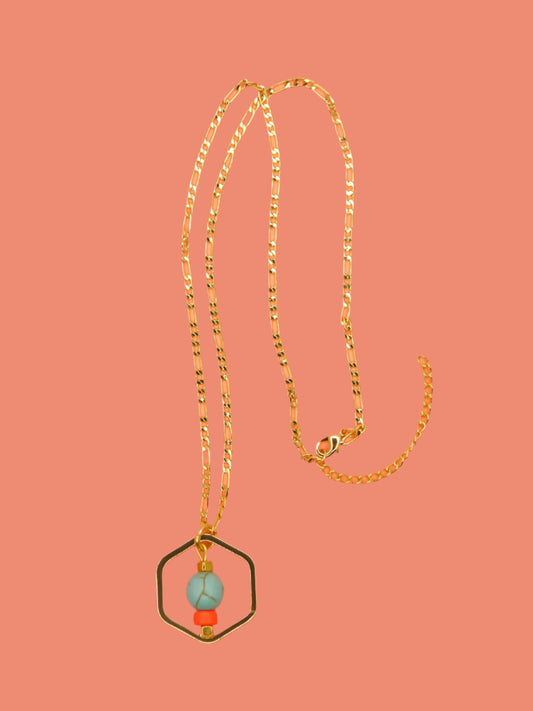 Geometric necklace comprising of a gold plated hexagon charm with a turquoise gemstone bead in the centre with an orange ceramic and brass square bead. Hung from a 24k shiny gold faceted curb chain with extender