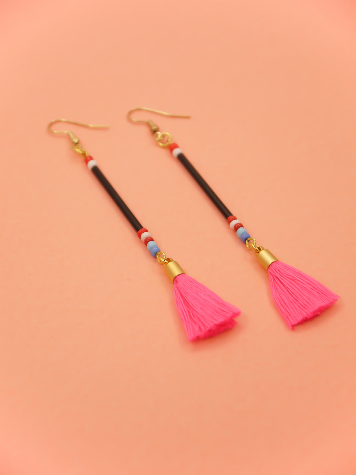 Long delicate bead tassel dangle earrings with black glass beads & multicoloured seed beads with a hot pink cotton tassel hung from gold plated nickel free ear wires