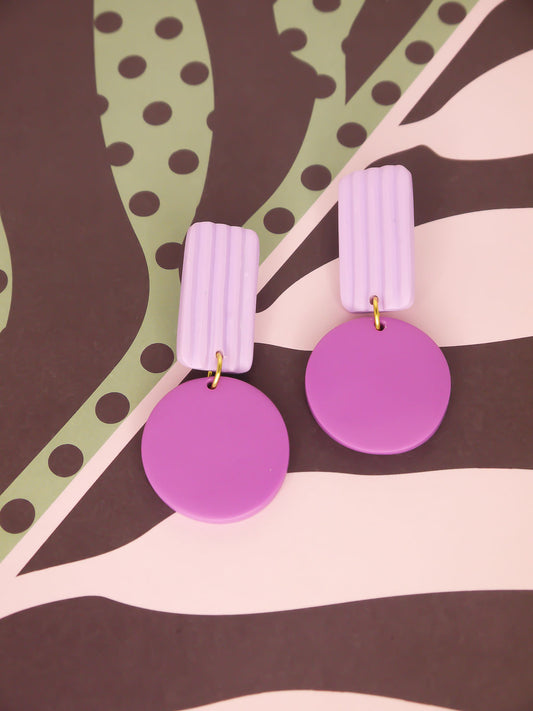 Purple striped geometric earrings on a patterned background
