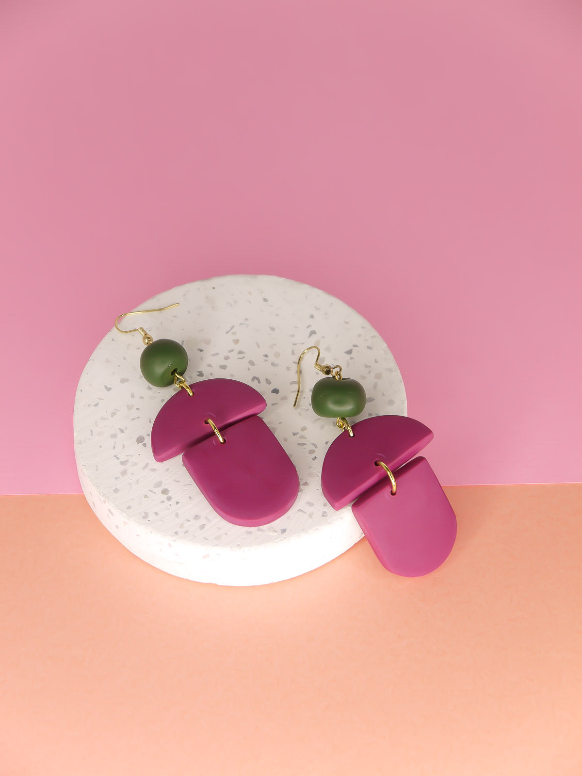 Geometric lightweight dangle statement earrings in magenta arch and semi circles with a hand rolled green bead hung from gold plated nickel free ear wires