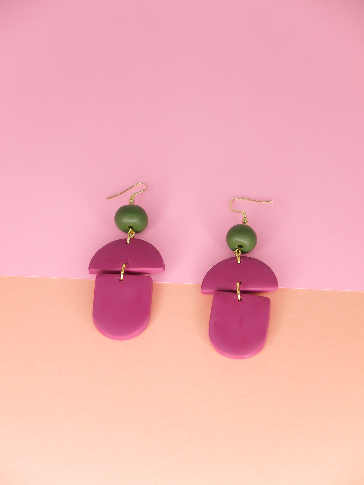 Geometric lightweight dangle statement earrings in magenta arch and semi circles with a hand rolled green bead hung from gold plated nickel free ear wires