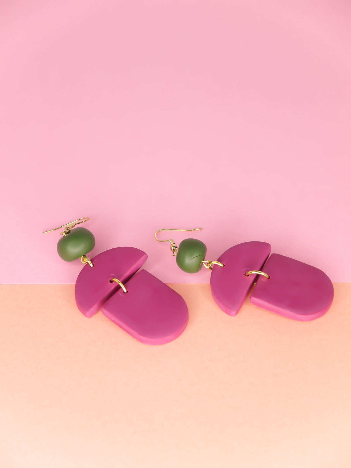 Geometric lightweight dangle statement earrings in magenta arch and semi circles with a hand rolled green bead hung from gold plated nickel free ear wires