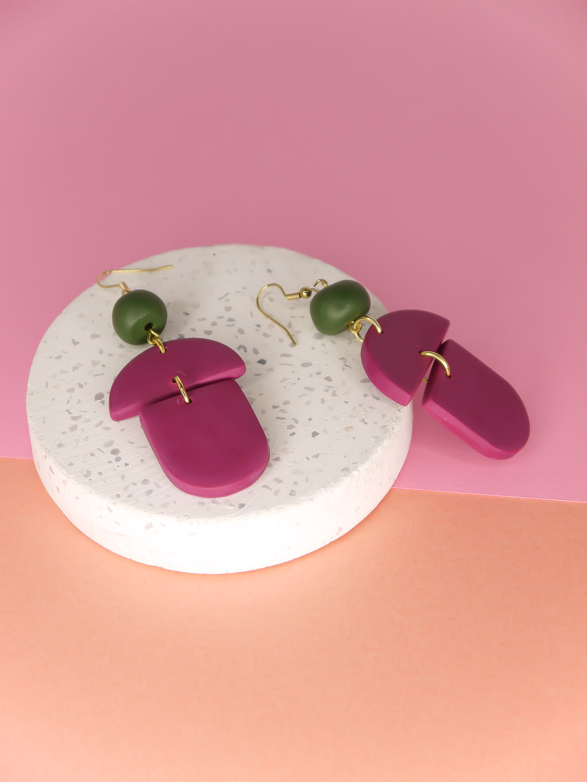 Geometric lightweight dangle statement earrings in magenta arch and semi circles with a hand rolled green bead hung from gold plated nickel free ear wires