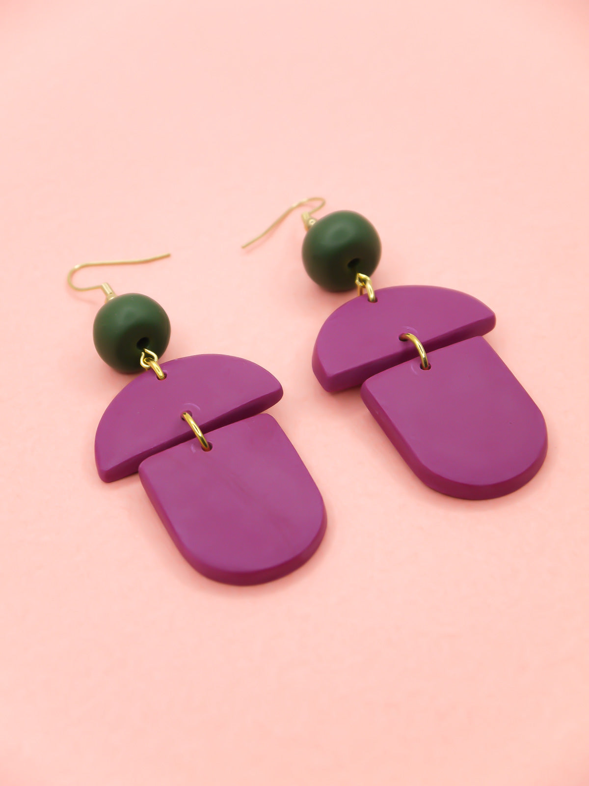 Geometric lightweight dangle statement earrings in magenta arch and semi circles with a hand rolled green bead hung from gold plated nickel free ear wires