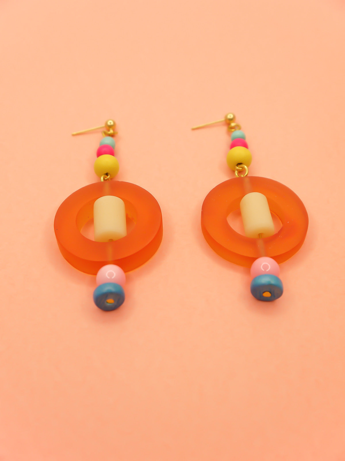 Colourful lightweight hoop bead earrings with glass & wood beads in yellow, pink & turquoise with a resin orange hoop in the centre & a resin cream tube bead in the middle. Hung from 24k gold plated ball studs.