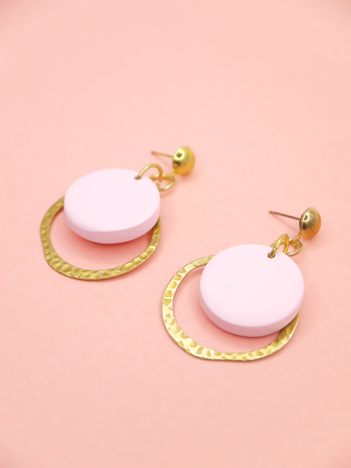 Geometric modern hoop dangle earrings with a textured brass hoop and a pastel pink polymer clay disk with gold plated brass studs