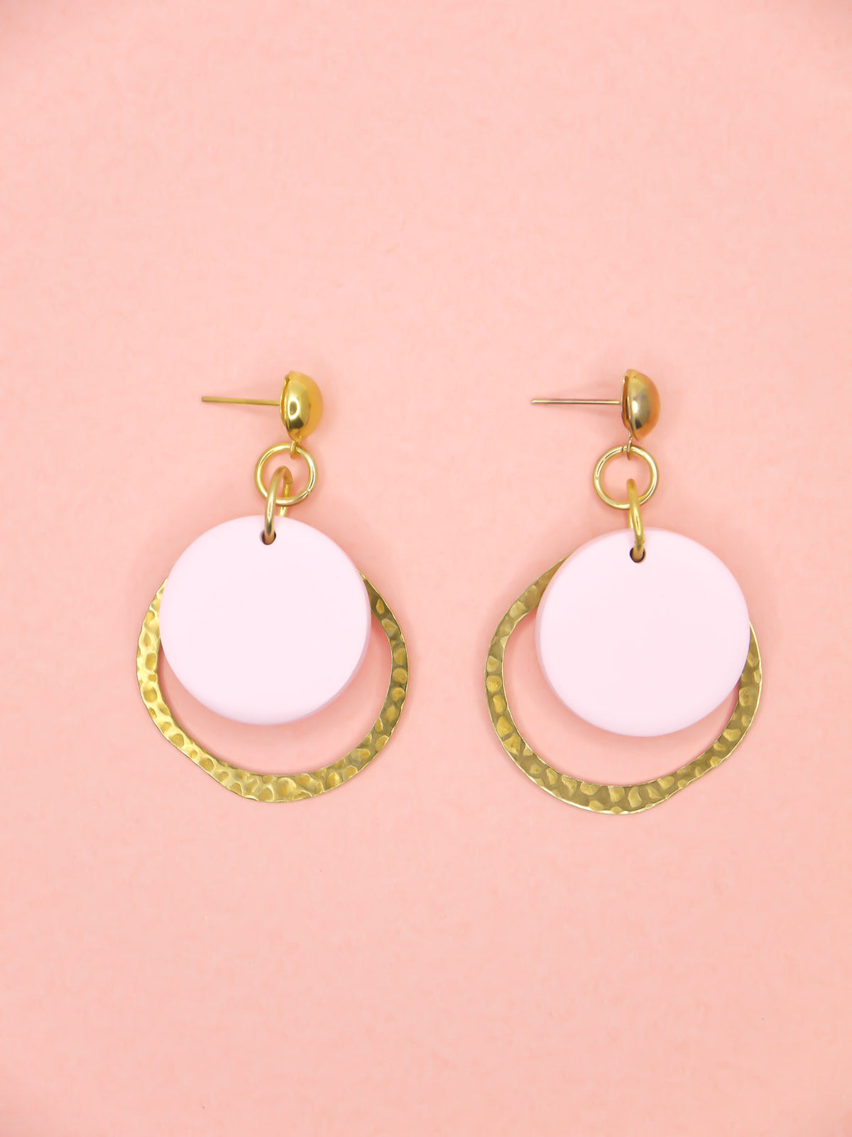 Geometric modern hoop dangle earrings with a textured brass hoop and a pastel pink polymer clay disk with gold plated brass studs