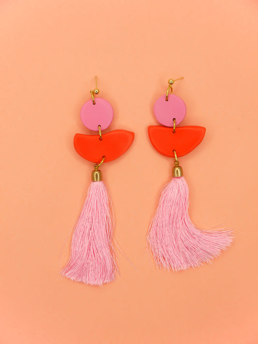 Statement dangle earrings with 24k gold plated ball studs connected to a pink polymer clay circle & a red polymer clay semi circle with a pale pink long tassel