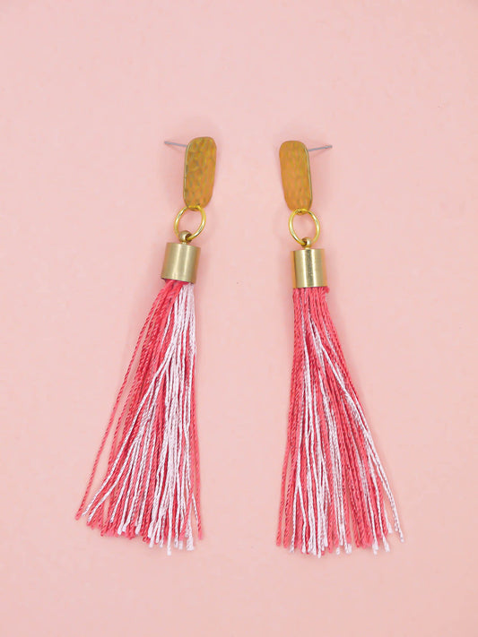 Pink & red tassel earrings with textured brass studs on a pink background