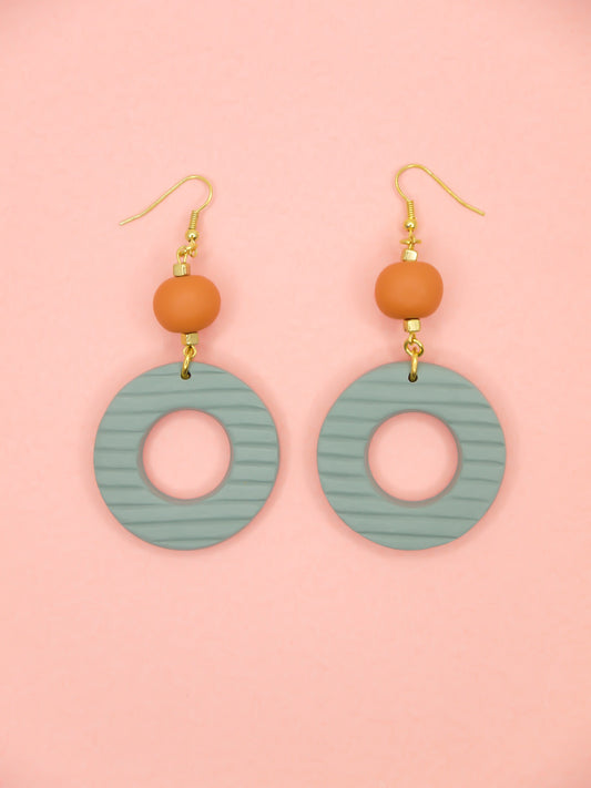 Geometric polymer clay statement dangle earrings with sage striped textured hoops, connected to terracotta ball beads and hung from brass ear wires.