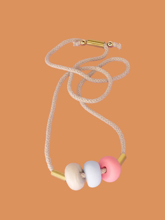 Modern lightweight polymer clay bead necklace comprising of three handmade beads in pink, ice blue and marble with two brass tubes either side strung on an adjustable beige cotton rope to wear short or long.