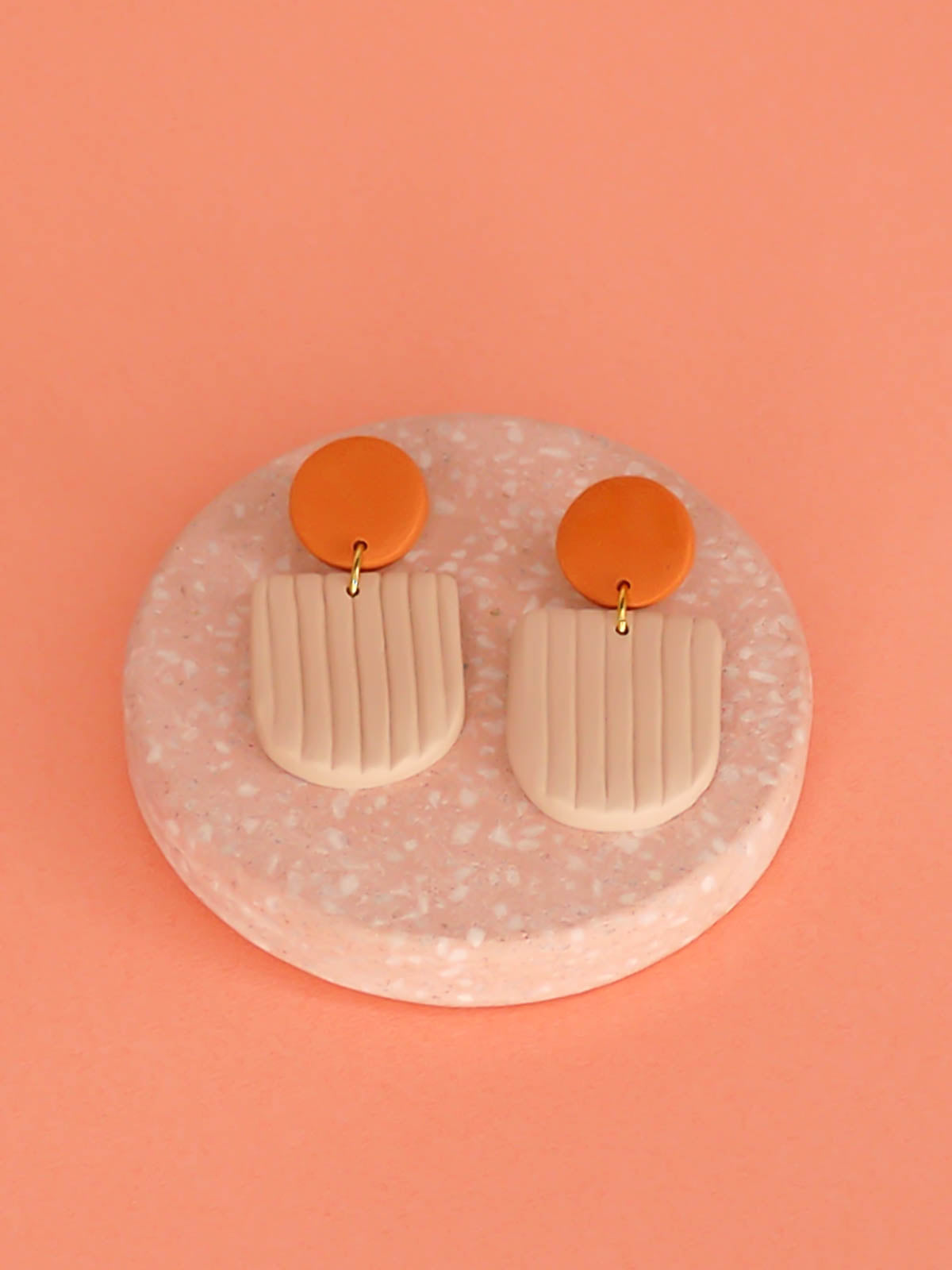 Modern arch dangle statement earrings in beige textured striped arch with a terracotta stud, made out of polymer clay with a stainless steel posts.