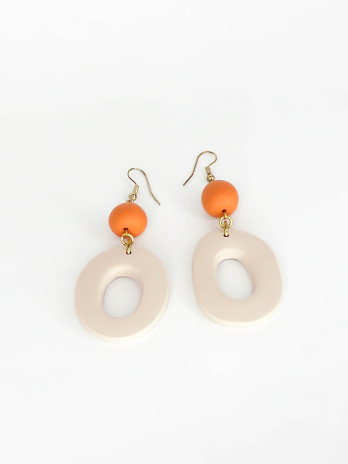 Modern hoop dangle statement earrings with a beige hoop & terracotta bead, hung from brass hooks. Handmade from polymer clay.