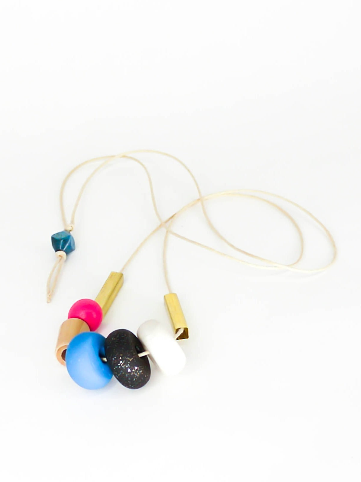 Lightweight geometric colourful bead necklace with 3 handmade polymer clay beads in marble, blue & black glitter- wood tube bead & pink wood bead, brass tube beads on either side, strung on a cotton cord with a blue wood bead knotted at the end