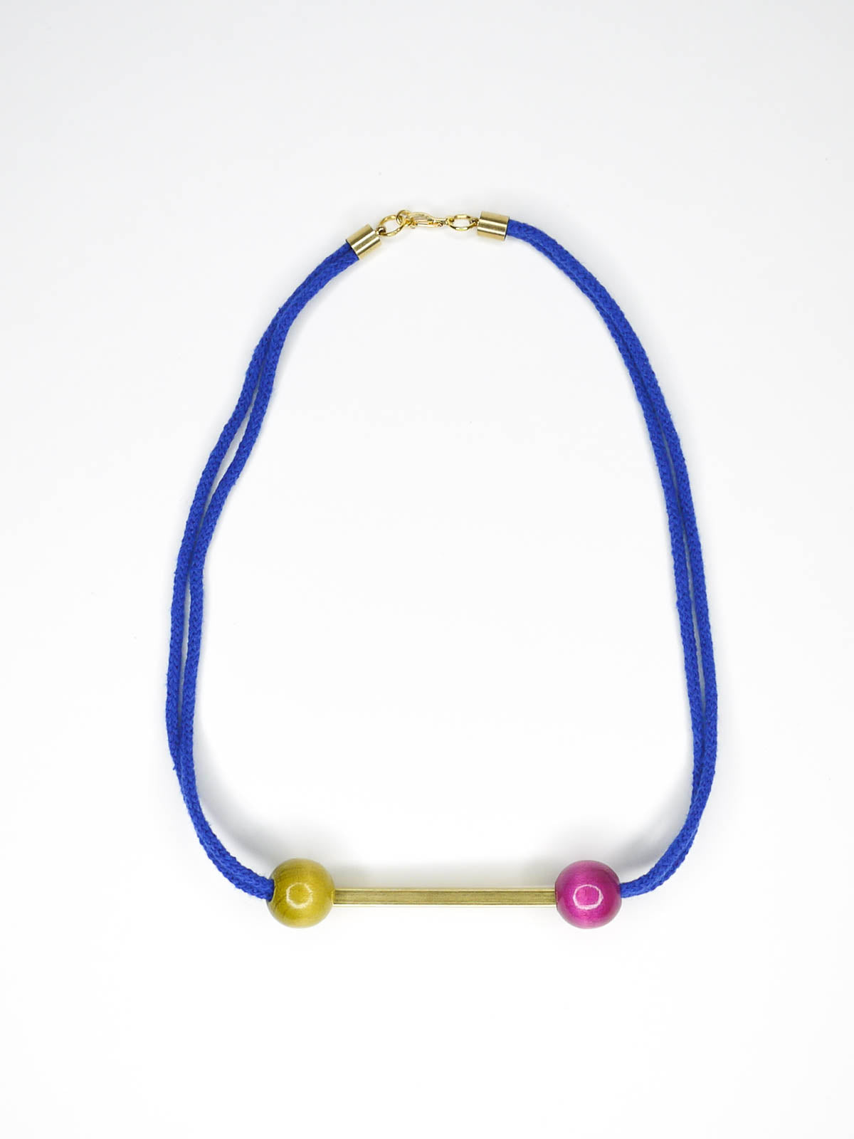 Cobalt blue rope bar necklace with a brass bar with contrasting wooden beads in pink and green with a brass clasp closure