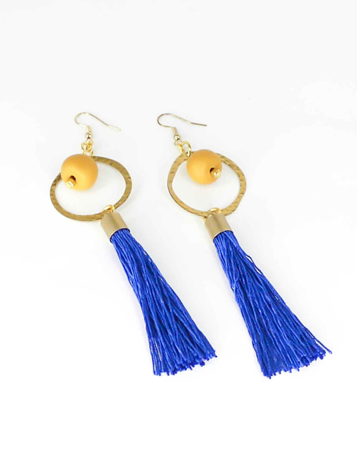 Long tassel statement earrings with gold plated ear wires, connected to a textured brass hoop with a mustard polymer clay bead dangling in the centre & a cobalt blue long tassel hung from the hoop